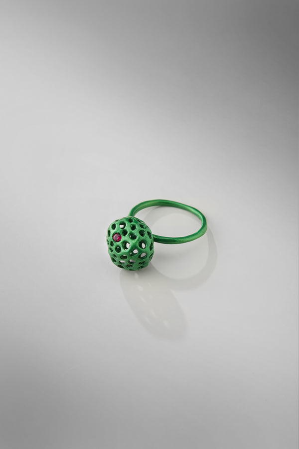 Green ring with a textured ball design on a gray background