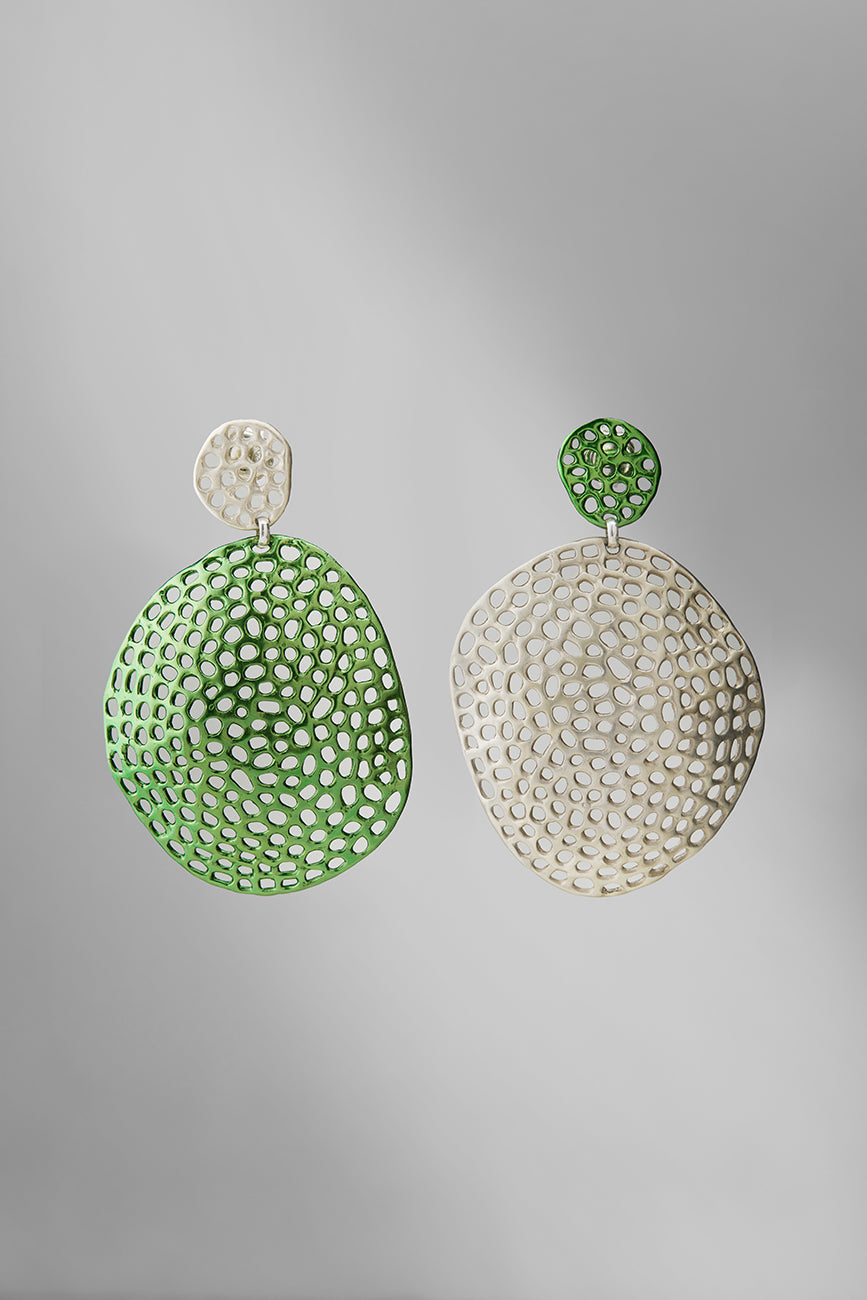 Pair of green and silver earrings on a gray background